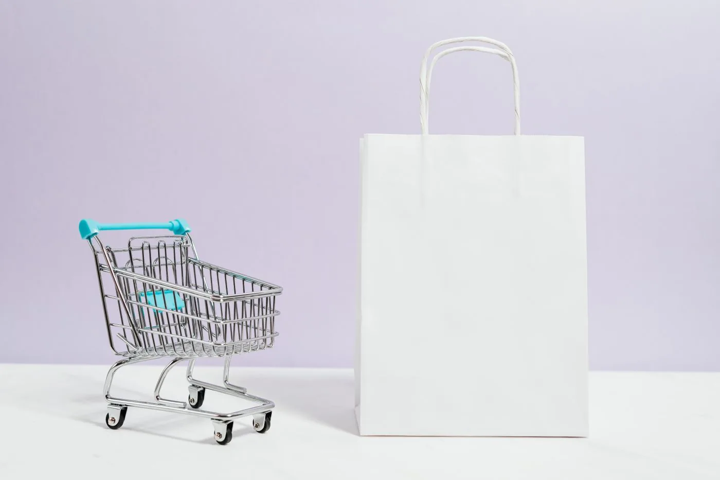 Mini shopping cart and white shopping bag for online retail. Photo by www.kaboompics.com on Pexels