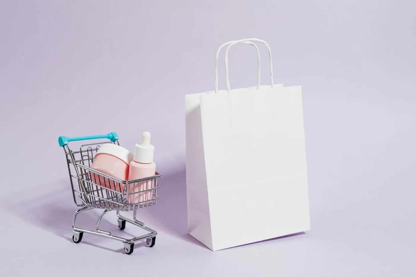 Branded beauty products in a cart next to a shopping bag. Photo by www.kaboompics.com on Pexels