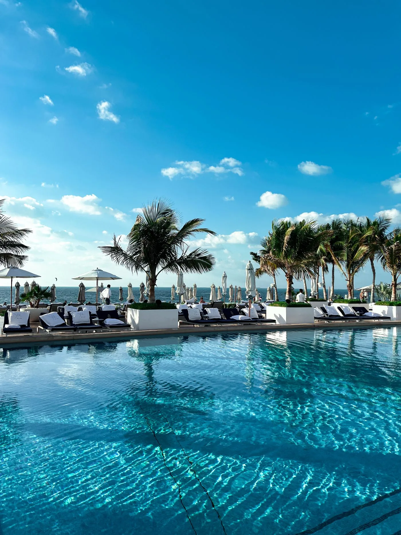 Swimming pool and deck chairs at a luxury hotel resort. Photo by Vincent Rivaud on Pexels