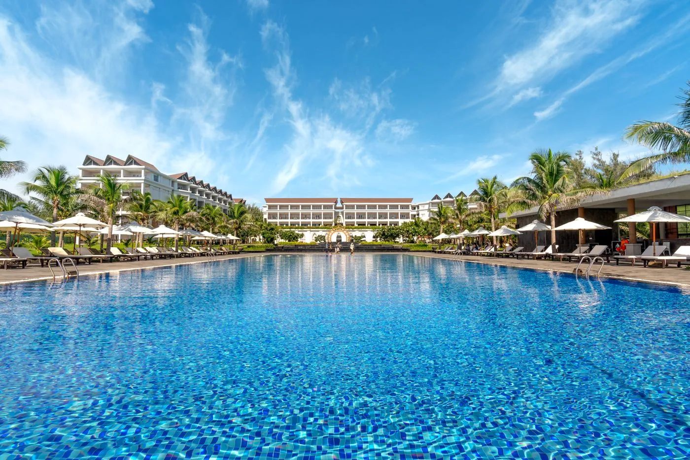 Large swimming pool outside a luxury hotel resort. Photo by Quang Nguyen Vinh on Pexels