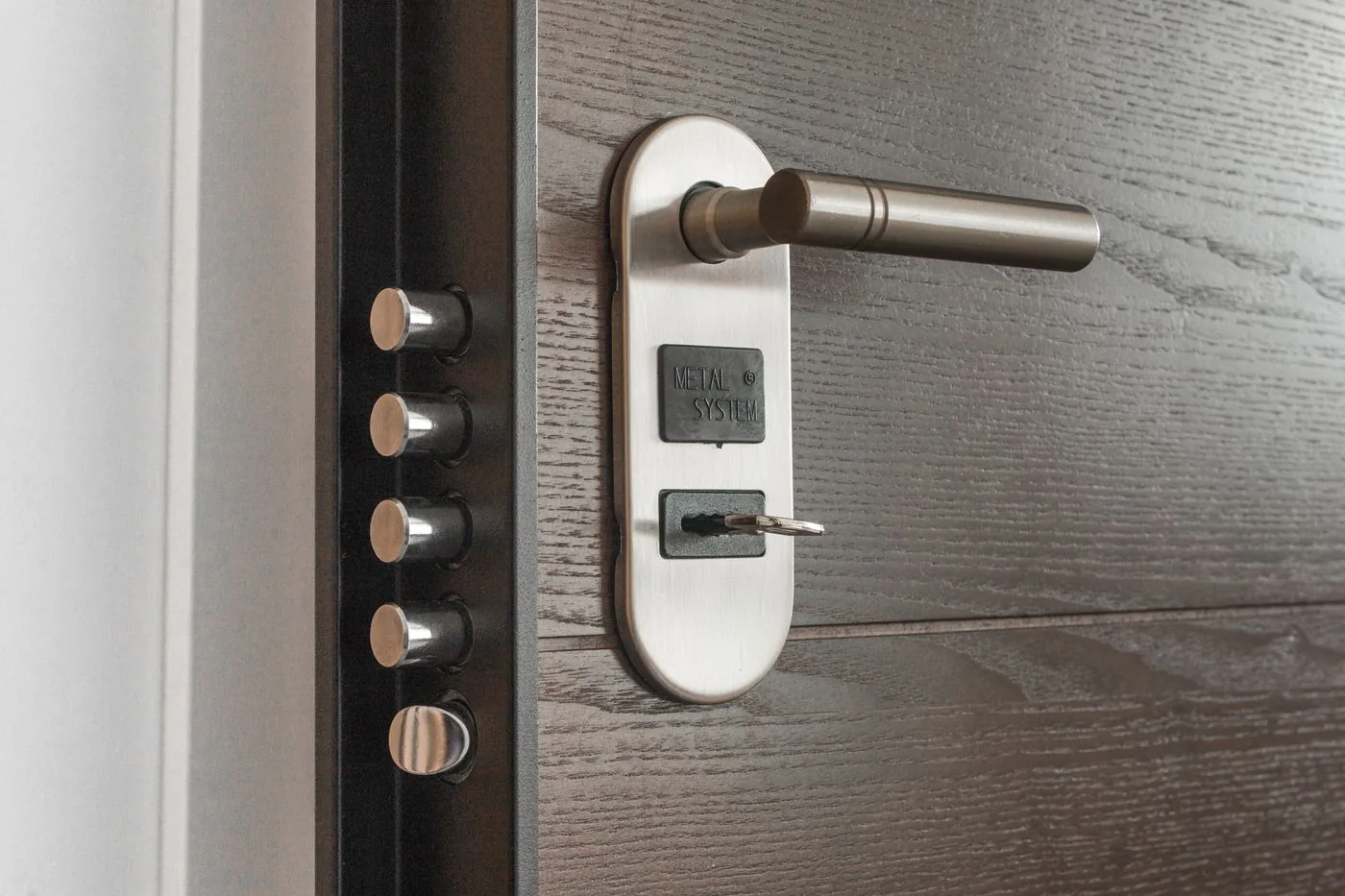 Modern multi-point door lock with key in the cylinder. Photo by Pixabay on Pexels