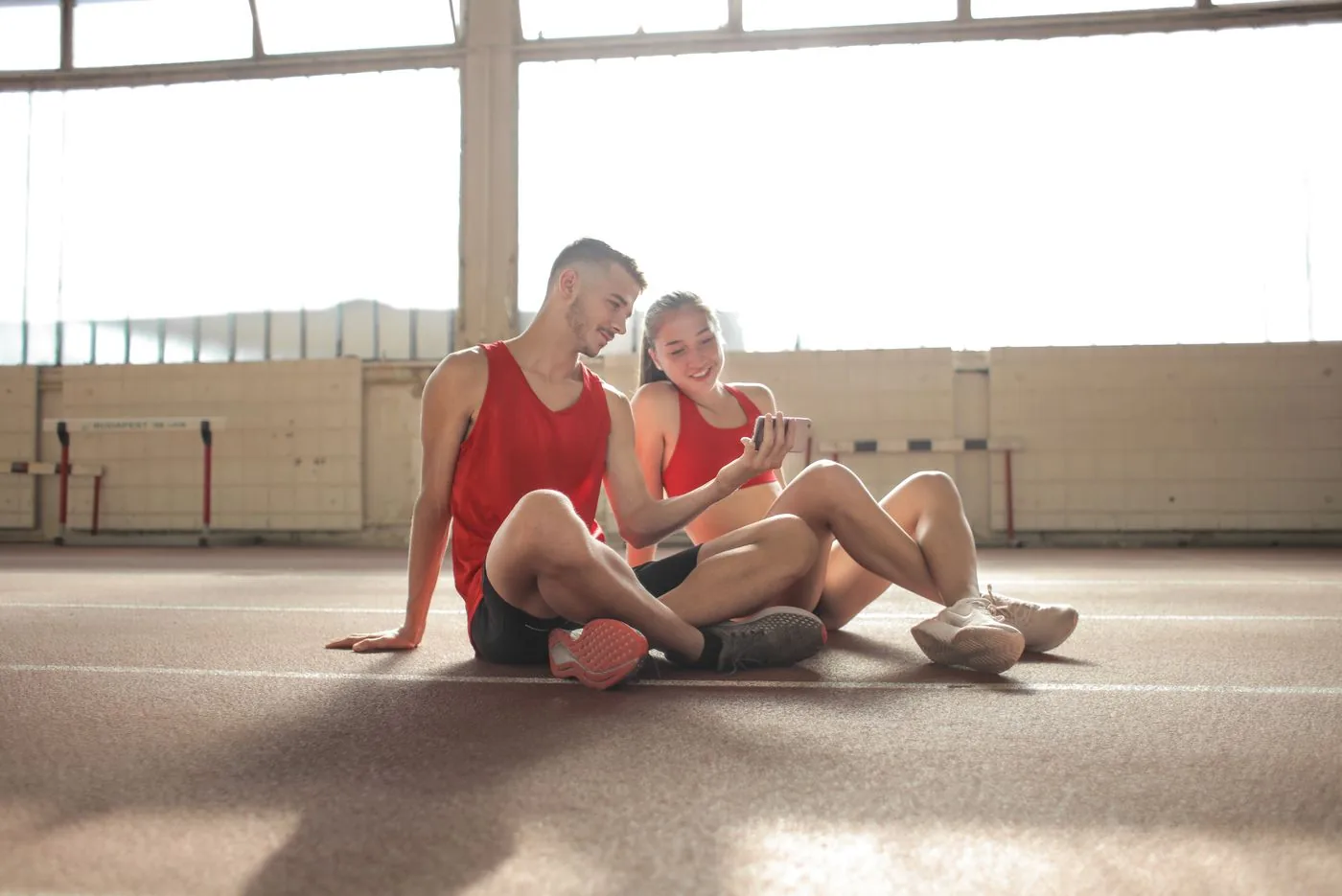 Athletes checking a mobile booking app after training. Photo by Andrea Piacquadio on Pexels