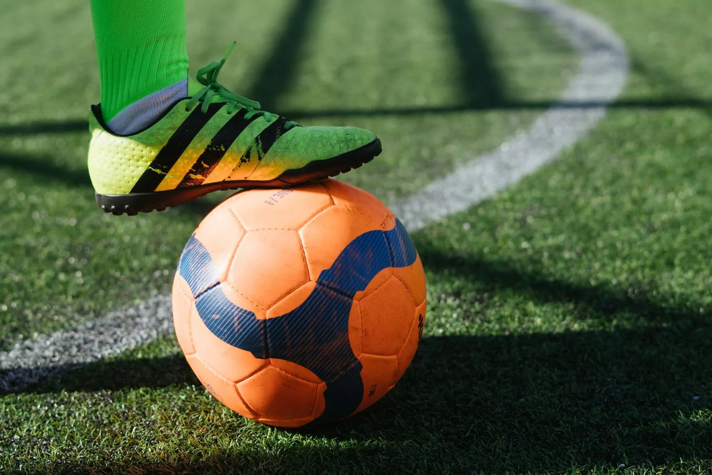 Football boot resting on a ball during a league match. Photo by RF._.studio _ on Pexels