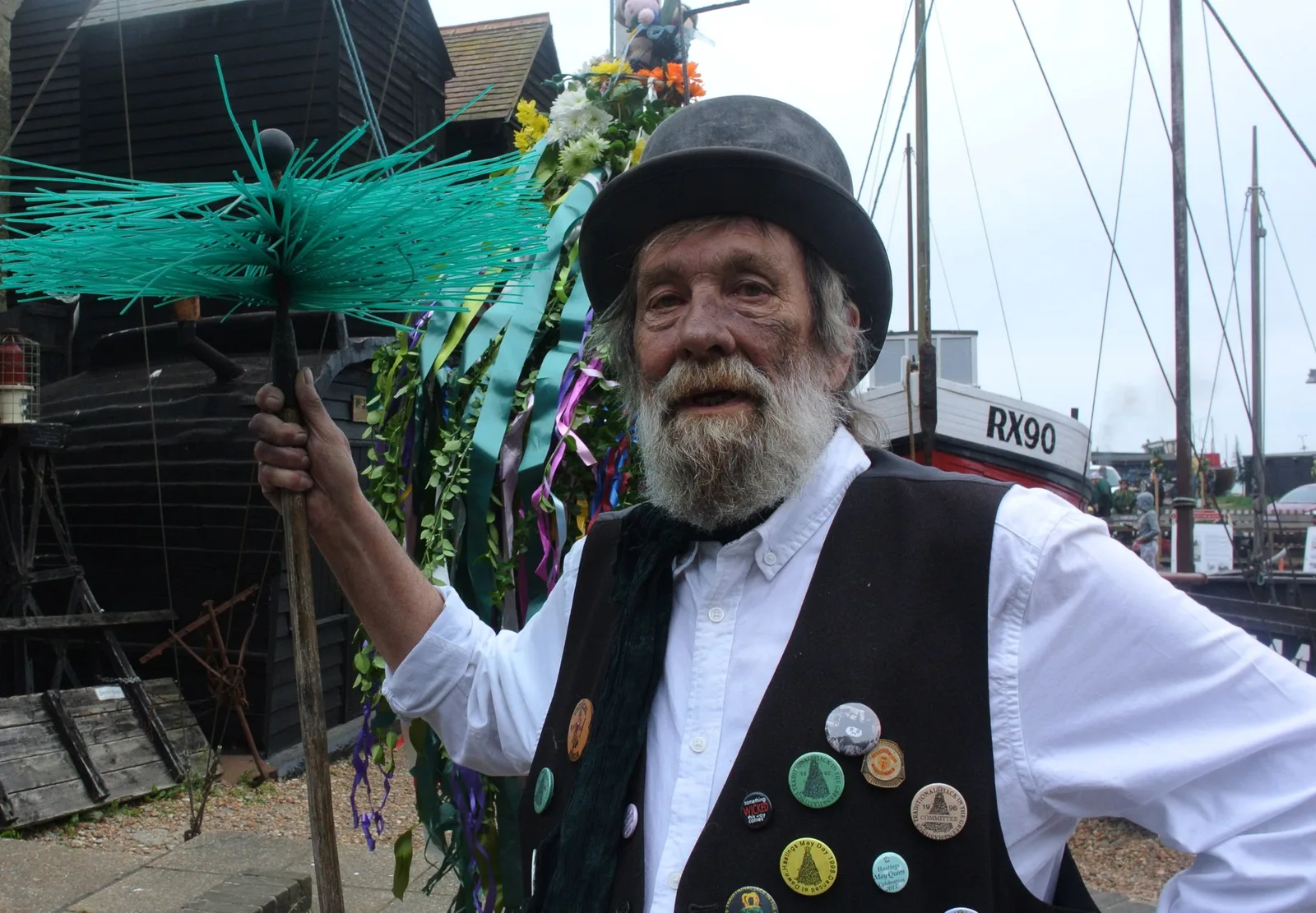 Elderly man in traditional costume participating in outdoor festival with vibrant decorations and boats in the UK. Photo by Nick on Pexels