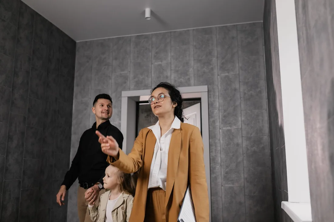 A family explores a modern home interior with a professional realtor guiding them in Australia. Photo by Alena Darmel on Pexels