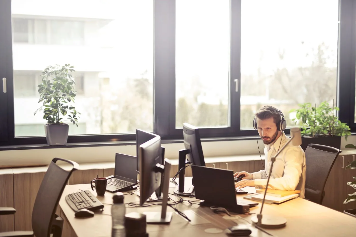Person working at multiple monitors in an office. Photo by Andrea Piacquadio on Pexels
